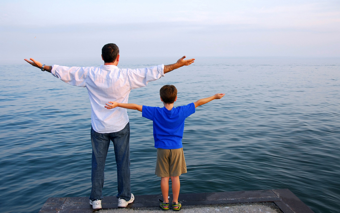 Man and Son Standing on the Edge of a Sea